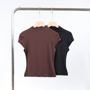 Detail of high-stretch mock neck short sleeve tops in brown and black on metal hangers