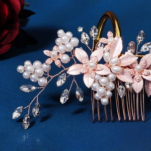 Detailed view of rose gold bridal hair comb with elegant pearls and crystal flower motifs