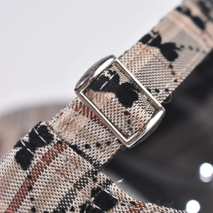 Macro view of adjustable checkered strap and silver metal buckle on the baseball cap