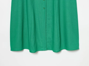 Detailed macro view of green linen blend fabric texture and matching front buttons