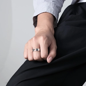 Minimalist silver couple ring featuring a hollow heart cutout worn on a male finger