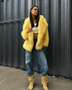 Street style shot of yellow faux fur coat with lapel and blue straight jeans