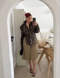 Detail of dark brown plaid long sleeve shirt paired with khaki high waist wide leg shorts