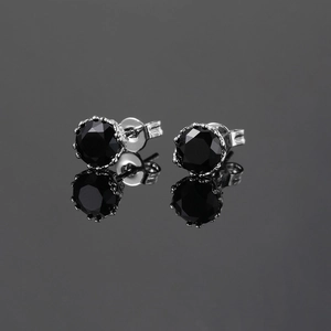Detail of silver stud earrings with round black zircon in a classic claw setting