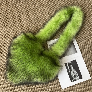 Detailed texture of bright green faux fur crossbody bag on a textured background