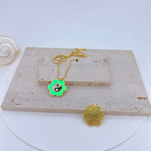 Gold plated cherry blossom necklace with green enamel flower and Tai Chi motif