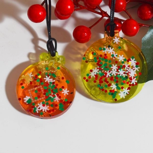 Vue détaillée de pendentifs de Noël en résine avec flocons et paillettes