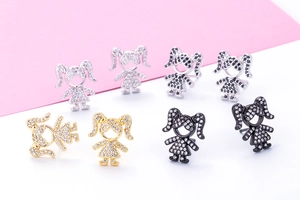 Detailed view of girl-shaped stud earrings in silver, gold, and black with zircon stones