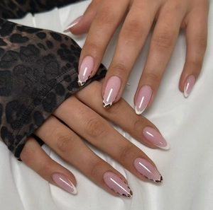 Close-up of long oval press-on nails with French leopard print and glossy finish