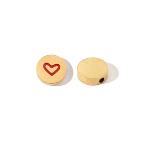 Macro detail of golden flat round bead with a red heart pattern for DIY jewelry