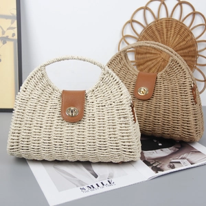 Fashionable straw crossbody bag with leather trim and gold metal twist lock for beach vacations