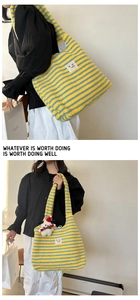 Detail of blue and yellow striped plush tote bag with a cute puppy keychain accessory