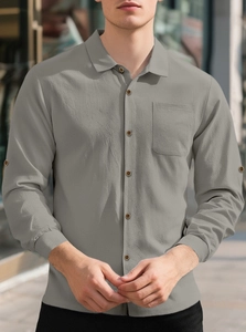 Detailed texture of grey linen long sleeve shirt featuring a front pocket and button collar