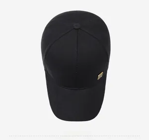 Top view of a black cotton baseball cap showing six-panel structure and metal plate detail