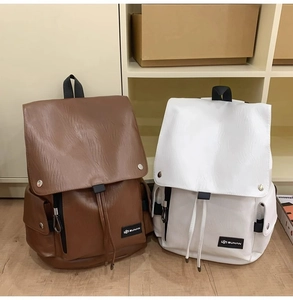 Dettaglio degli zaini in ecopelle marrone scuro e bianco con chiusura a coulisse