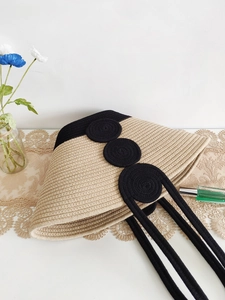 Handwoven beige and black cotton rope beach tote bag with circular accents and long straps