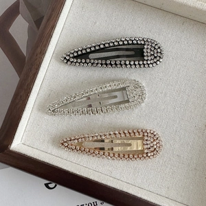 Three-piece set of teardrop rhinestone hair clips in black, silver, and rose gold colors