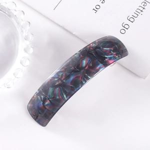 Detail of a rectangular dark checkered hair clip made of premium acetate material