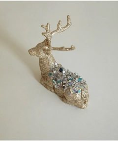 Detailed view of reclining golden reindeer ornament with glitter and silver sequins