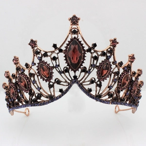 Close-up of Baroque black crown featuring red crystals and intricate antique metalwork