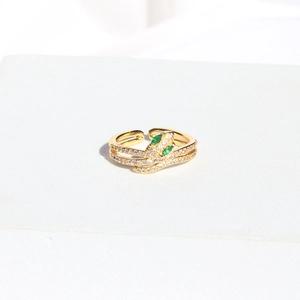 Detailed view of adjustable gold snake ring with green zircon stones on stone base