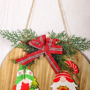 Round wooden Christmas welcome sign with gnome motifs, faux greenery, and plaid bow