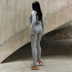 Women's grey two-piece workout set with zip-up jacket and split-leg flared pants