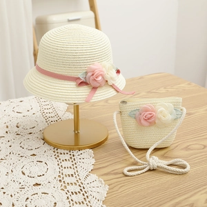 Détail d'un chapeau de paille pour enfant et sac assorti avec fleurs roses et rubans