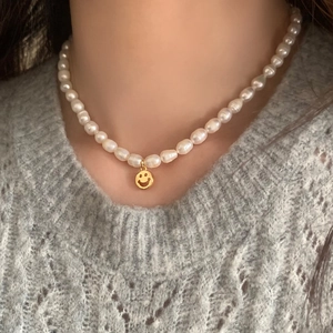 French vintage freshwater pearl necklace with gold smiley face heart pendant worn on neck