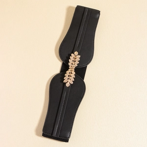 Detail of black elastic waist belt with an elegant golden leaf-shaped metal buckle