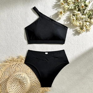 Detailed flat lay of black ribbed high waist bikini with straw hat and dry flowers