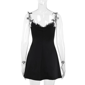 Détail d'une mini robe noire moulante avec bordures en dentelle et bretelles à nœuds élégantes