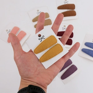 Detailed view of teardrop cashmere-texture hair clips in various autumn colors for kids