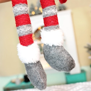 Detail von Weihnachts-Puppenbeinen mit rot-weißen Streifen und weichem Plüschrand
