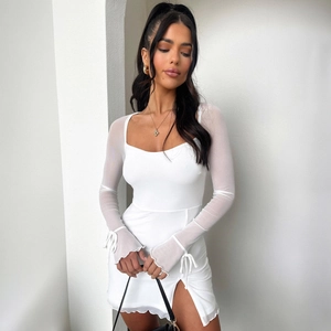 Detail of white mini dress featuring sheer mesh sleeves with tie cuffs and side slit