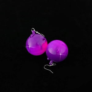 Close-up of purple disco ball earrings with reflective laser surface and silver hooks