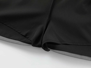 Close-up of high-quality sewing and gray trim on black A-line skirt fabric