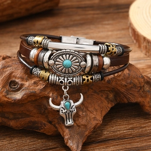 Detail of vintage multilayer leather bracelet with bull head charm and turquoise stone