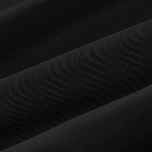 Close-up of black knit fabric texture showing fine weave and premium material detail
