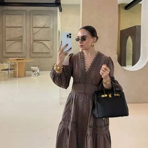 Selfie miroir montrant la broderie détaillée en V sur une robe longue en dentelle marron