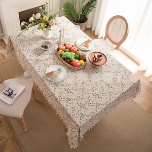 Detailed close-up of a floral cotton linen tablecloth featuring ivory fringes and patterns