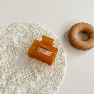 Macro detail of amber acetate shark hair claw clip with rectangular cutout design