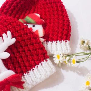 Detailed macro view of the festive red and white baby knitted hat with snowman and antlers