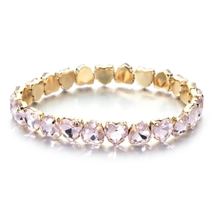 Detailed macro view of heart-shaped pink crystals set in gold-tone metal prongs for women