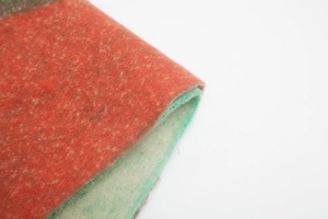 Close-up of thick boucle jacquard scarf fabric with vibrant red and green floral textures