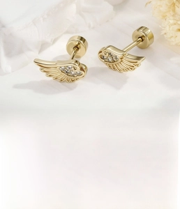 Detailed view of light coffee gold angel wing cartilage piercing with clear zircons