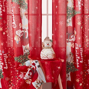 Red Christmas curtains with Santa and tree patterns creating a festive holiday atmosphere