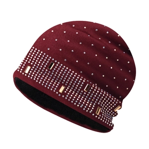Close-up of burgundy knit beanie with rhinestones and warm fleece lining texture