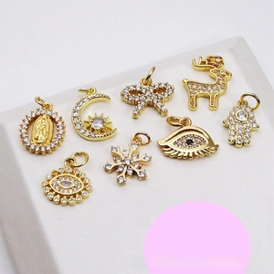 Detailed set of 8 gold-plated charms including butterfly, evil eye, and snowflake with zircons