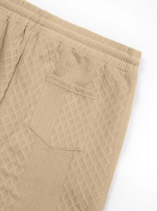 Detailed macro view of khaki waffle jacquard fabric texture and back pocket stitching